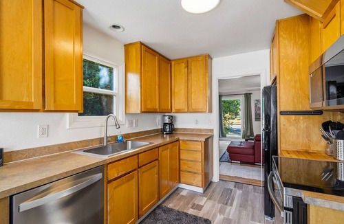 Downtown Vancouver House | Freshly renovated home with brand-new appliances, a new big-screen TV, refinished hardwood floors, and all-new furniture throughout. Sink into the plush leather sectional (pull-out queen sleeper) or dine at the six-seat table in the garden.