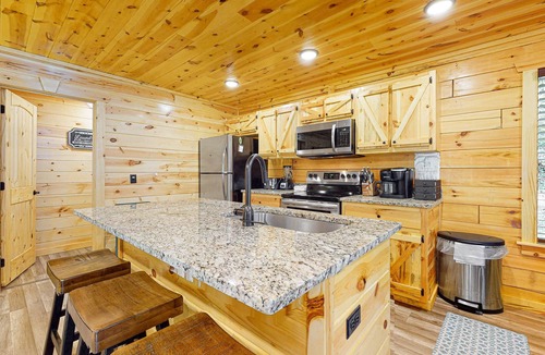 Chalet Village North Cabin | Wooded cabin w/hot tub, fireplaces, & furnished deck